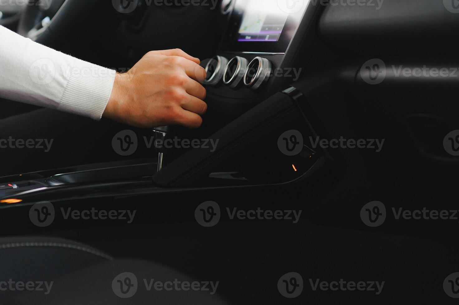 Male hand on the shift lever of the transmission in the car photo