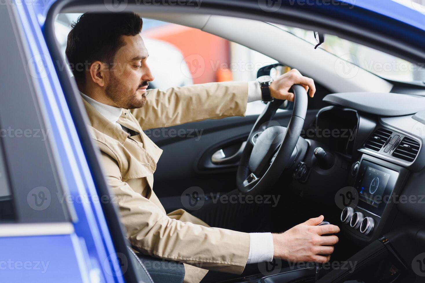 Close-up of man looking at his watch on his hand while sitting in his car he hurrying to a meeting photo