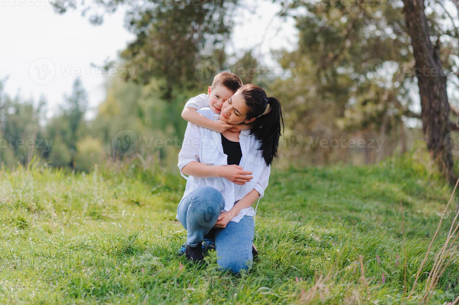 Happy family. Mother with son child playing having fun together on the grass in sunny summer day, life moment photo