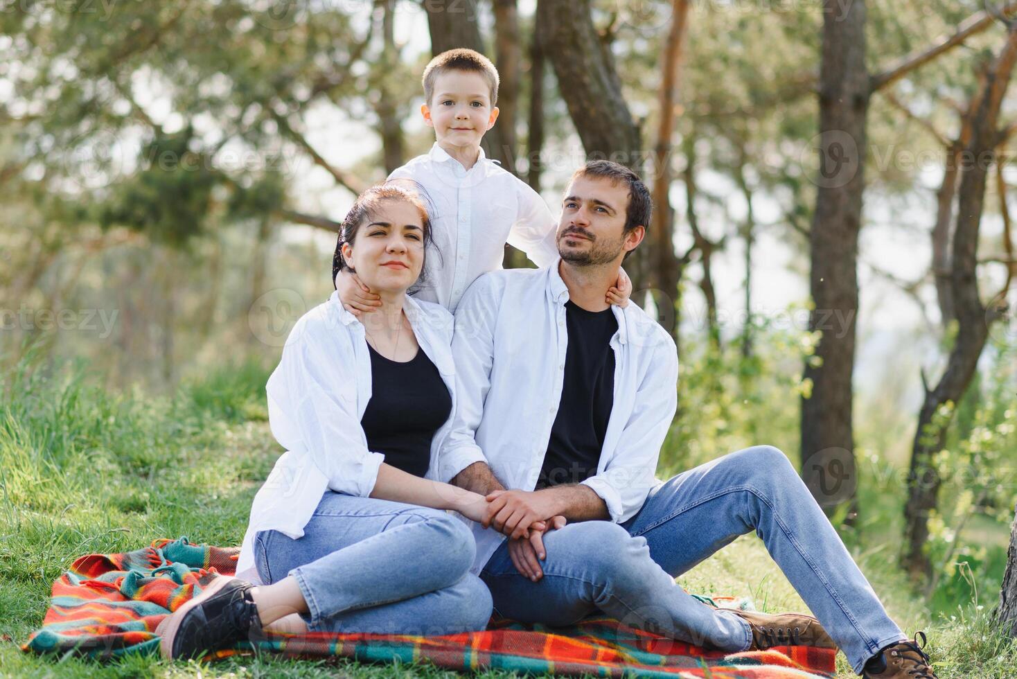 happy young couple with their children have fun at beautiful park outdoor in nature photo