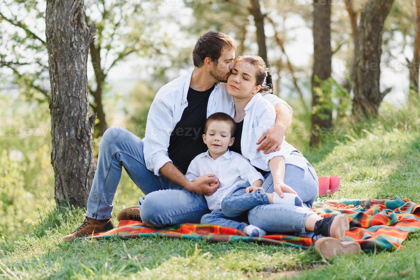 happy young couple with their children have fun at beautiful park outdoor in nature photo