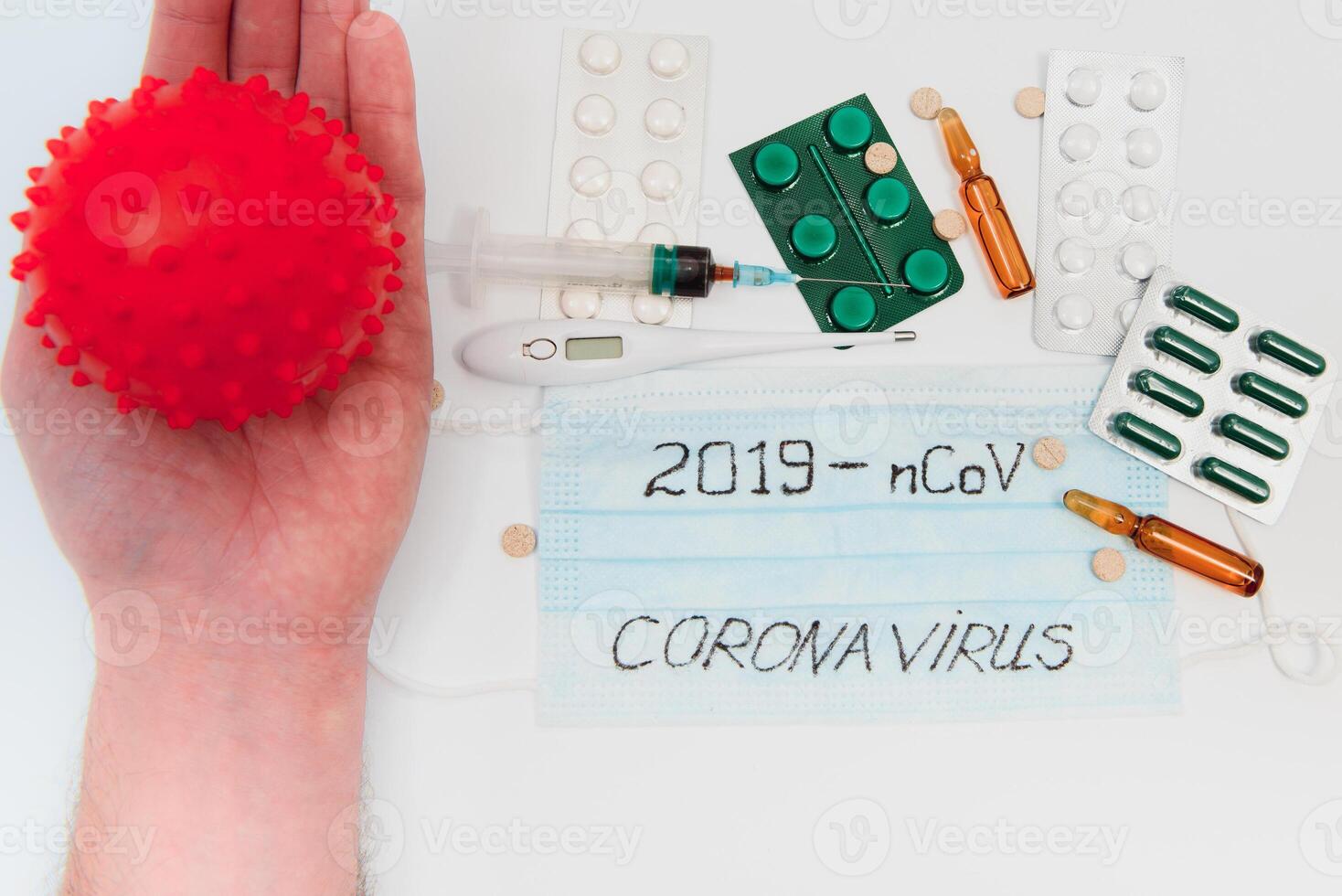 a test tube with a positive test for the CAVID-2019 coronavirus. medical devices on a white table. thermometer, phonendoscope, tablets, surgical masks photo