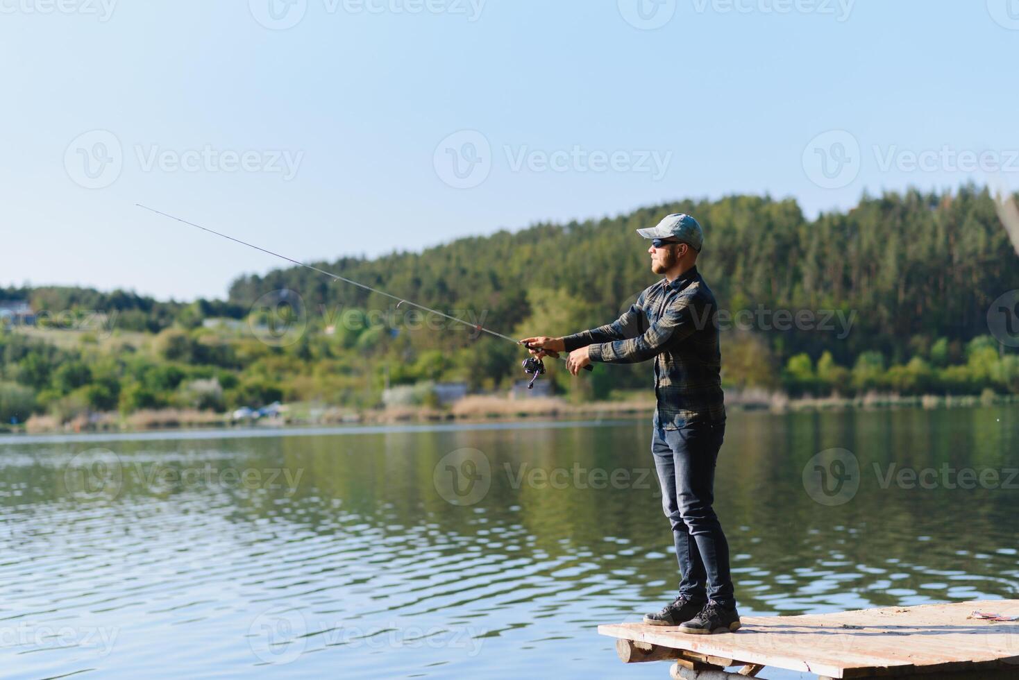 A man catches a fish on a spinning fishing in the summer photo