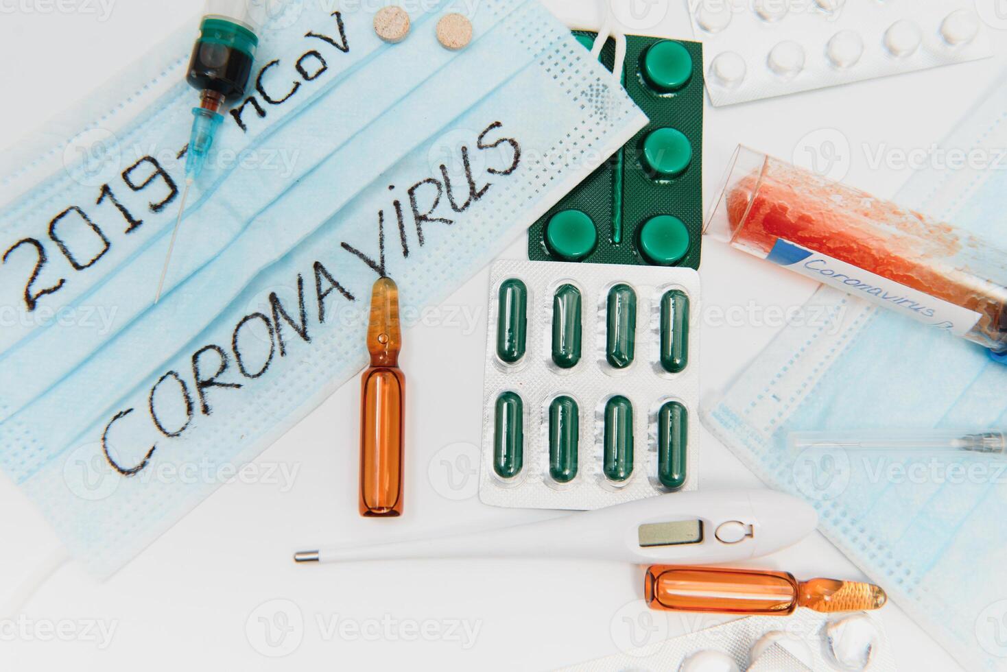 Surgical mask protective mask with CORONAVIRUS text. Virus 2019-n CoV in Wuhan, China. Tablets, mask, syringe photo