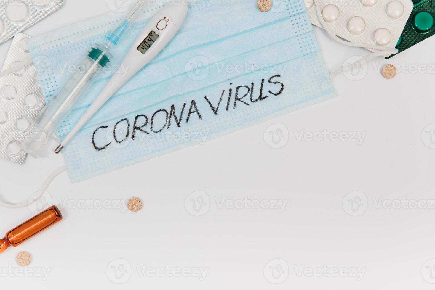 Surgical mask protective mask with CORONAVIRUS text. Virus 2019-n CoV in Wuhan, China. Tablets, mask, syringe photo