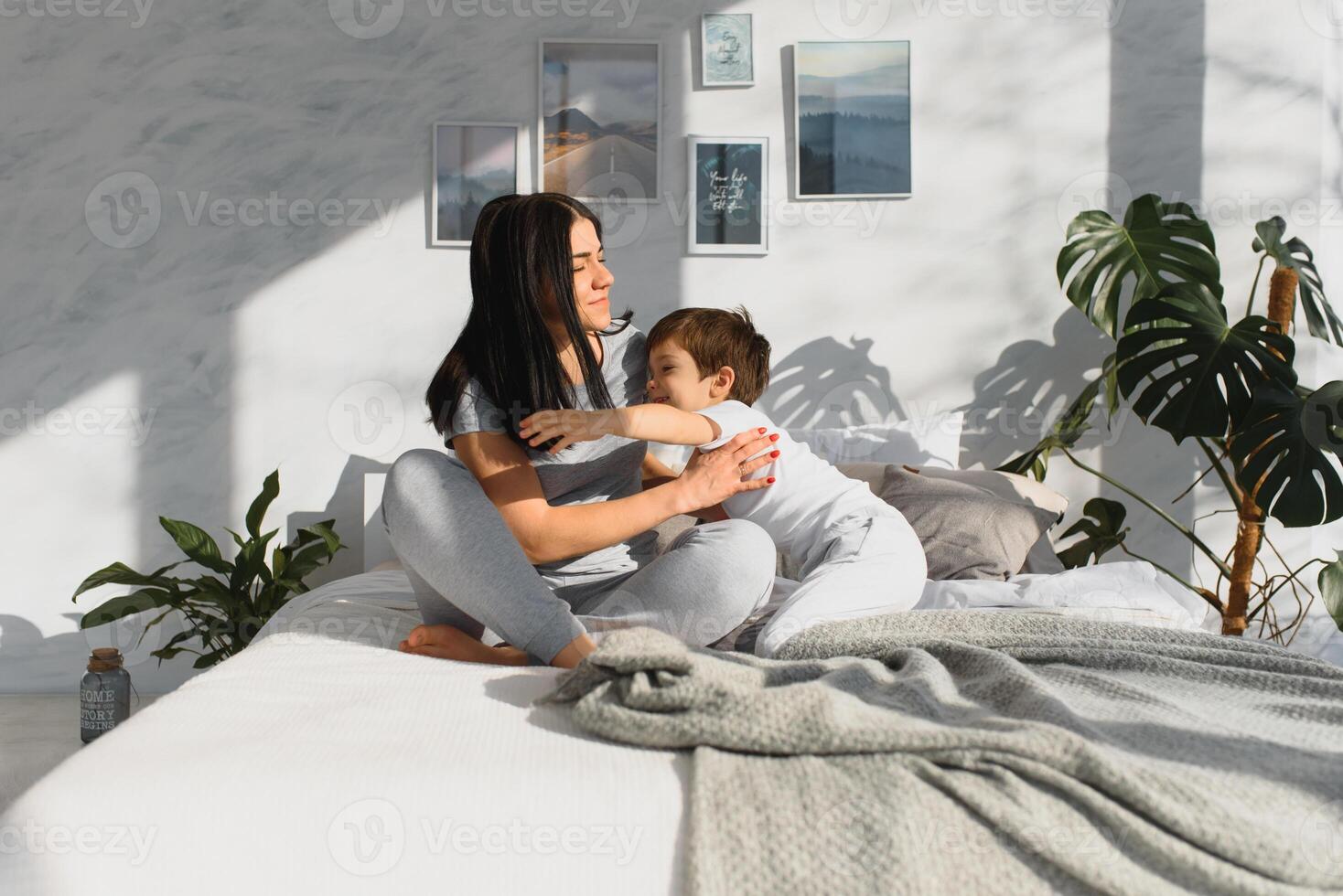 portrait of a happy family, mom and baby in the bedroom, mother and son are hugging photo
