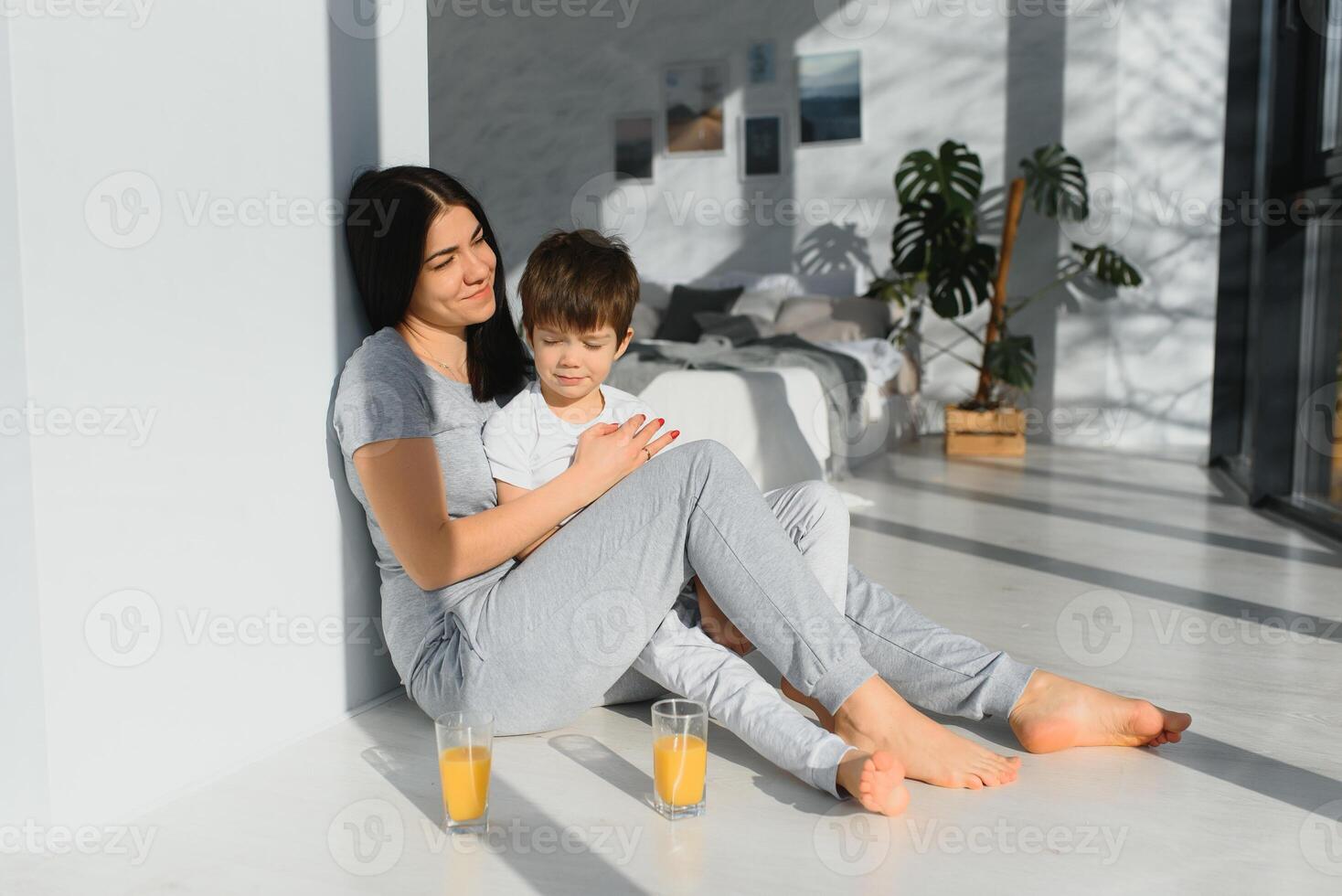 funny mom and son on the floor in the living room, concept motherhood and emotions photo