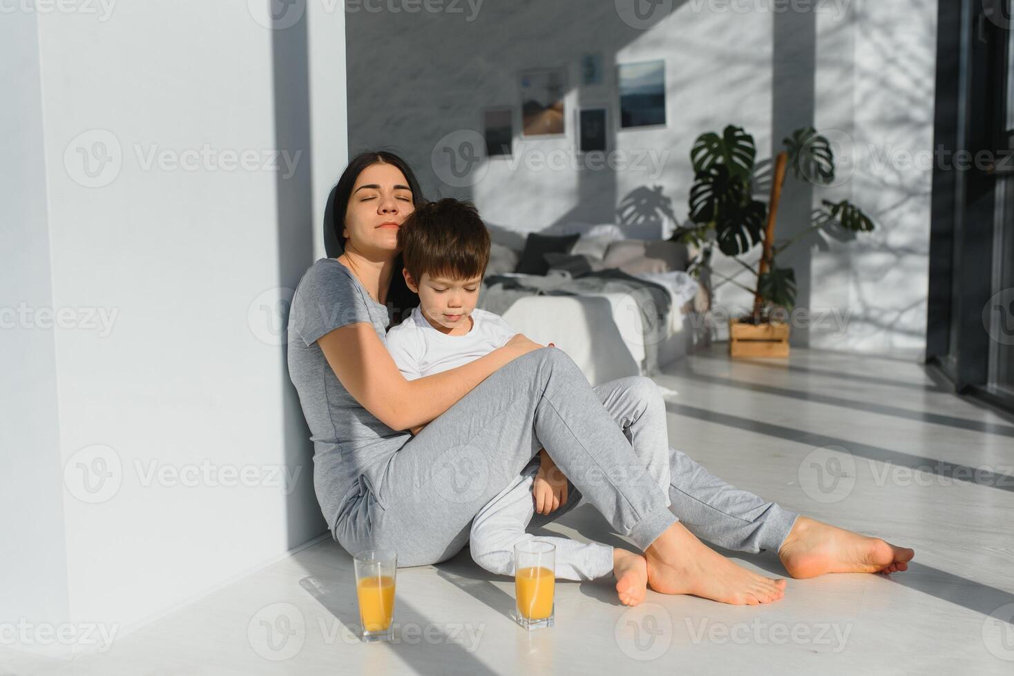 funny mom and son on the floor in the living room, concept motherhood and emotions photo