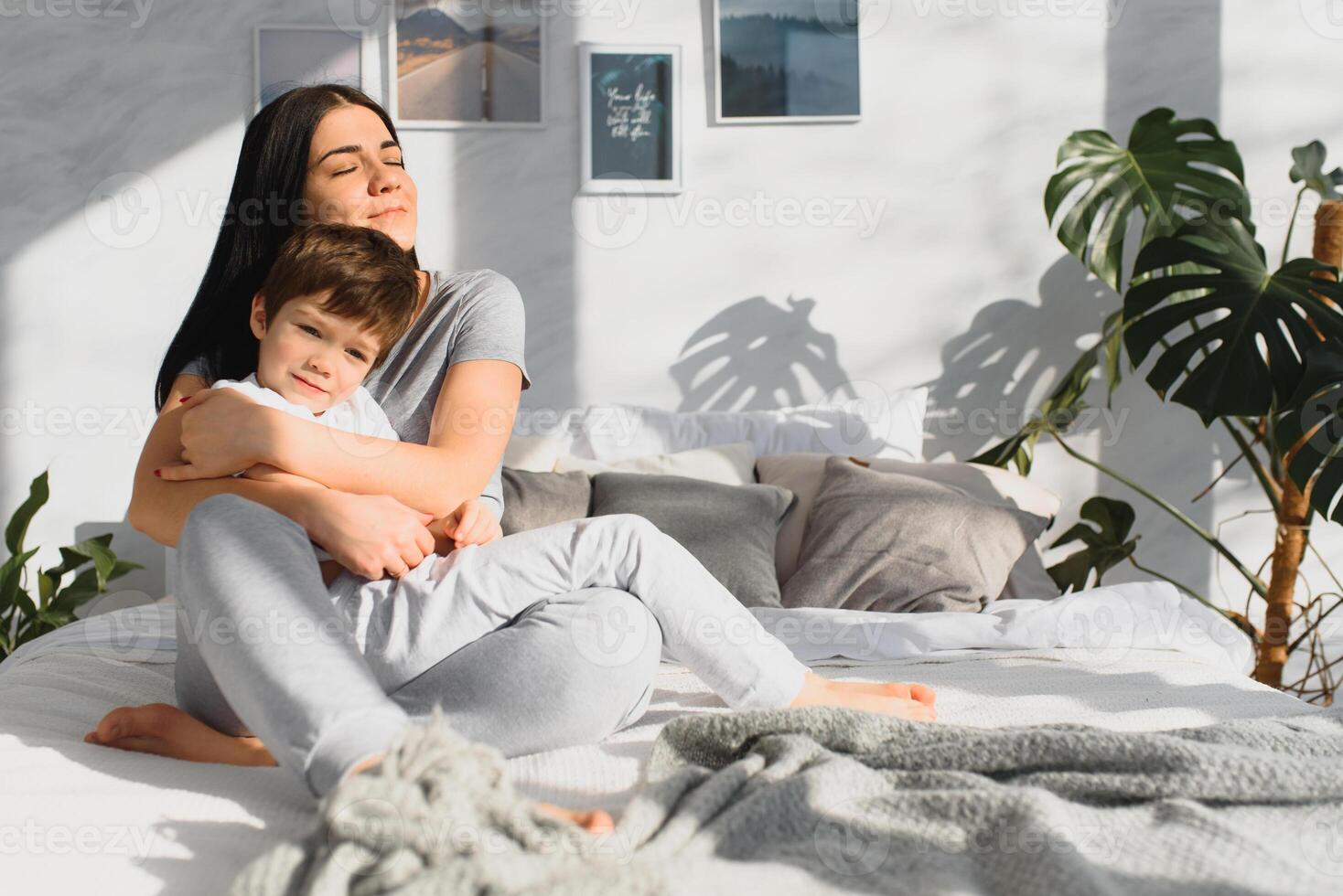 portrait of a happy family, mom and baby in the bedroom, mother and son are hugging photo