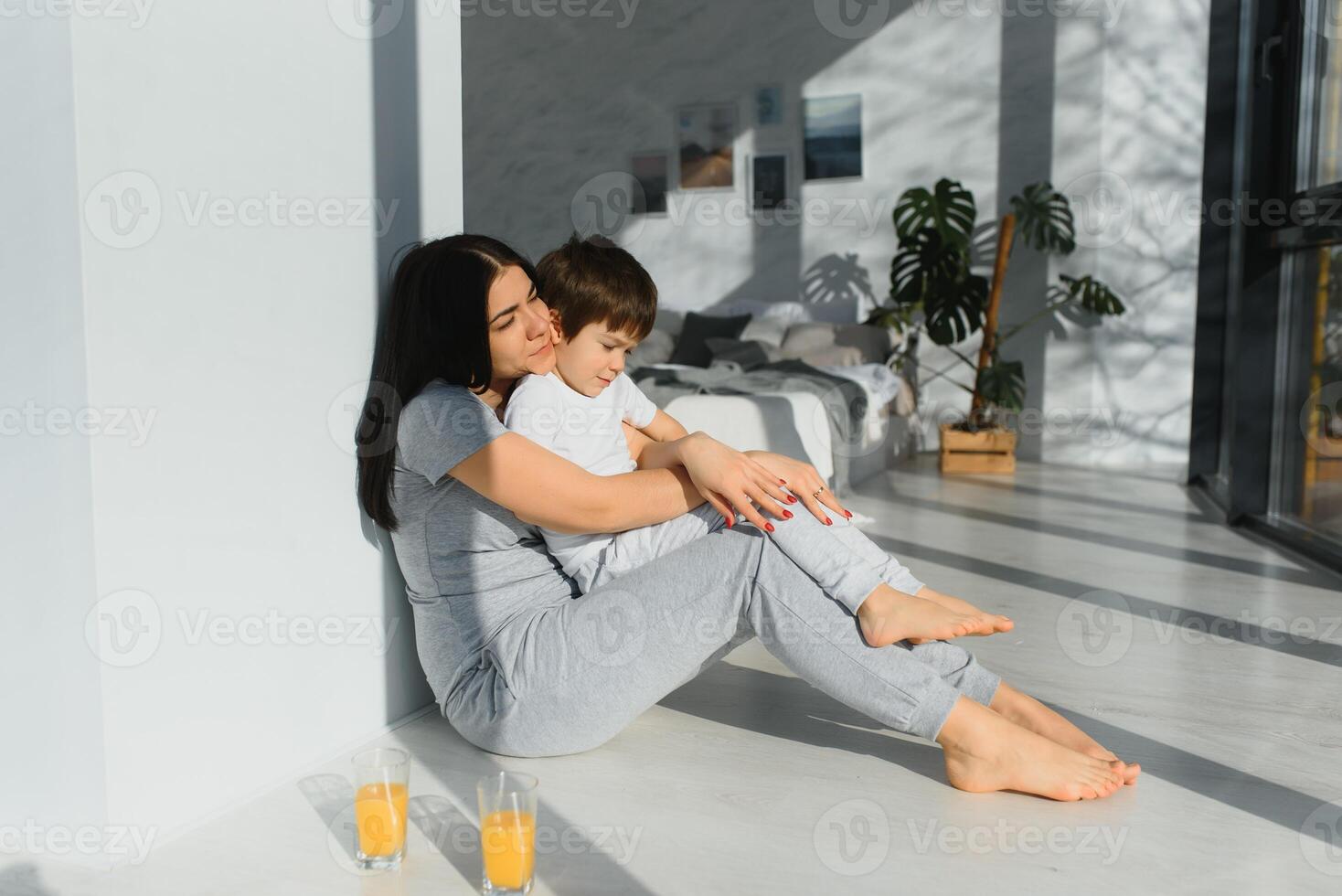 funny mom and son on the floor in the living room, concept motherhood and emotions photo