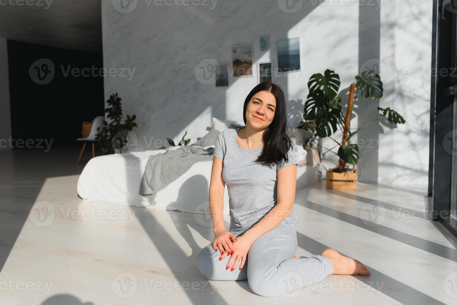 Beautiful woman waking up in her bed in the bedroom, she is stretching and smiling photo