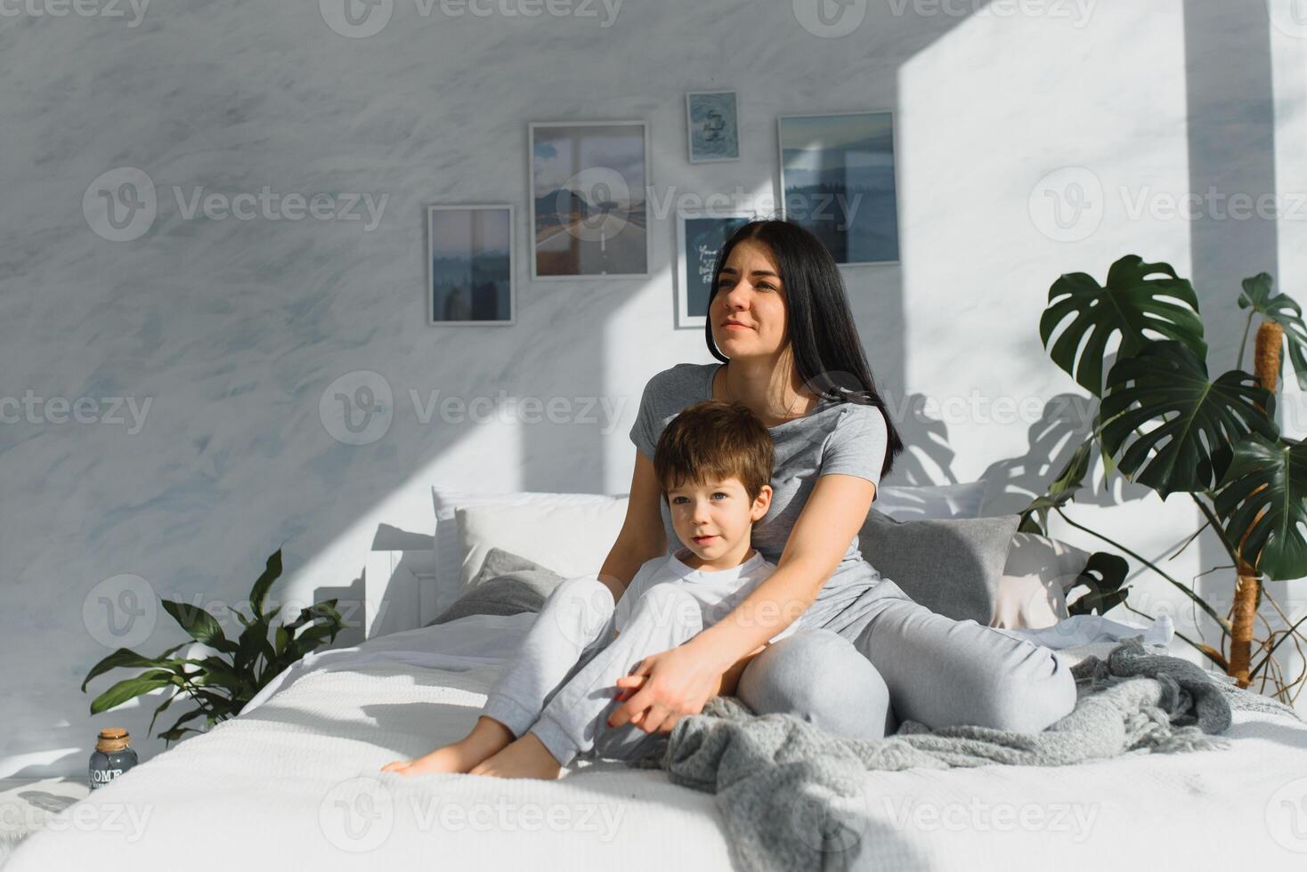 portrait of a happy family, mom and baby in the bedroom, mother and son are hugging photo