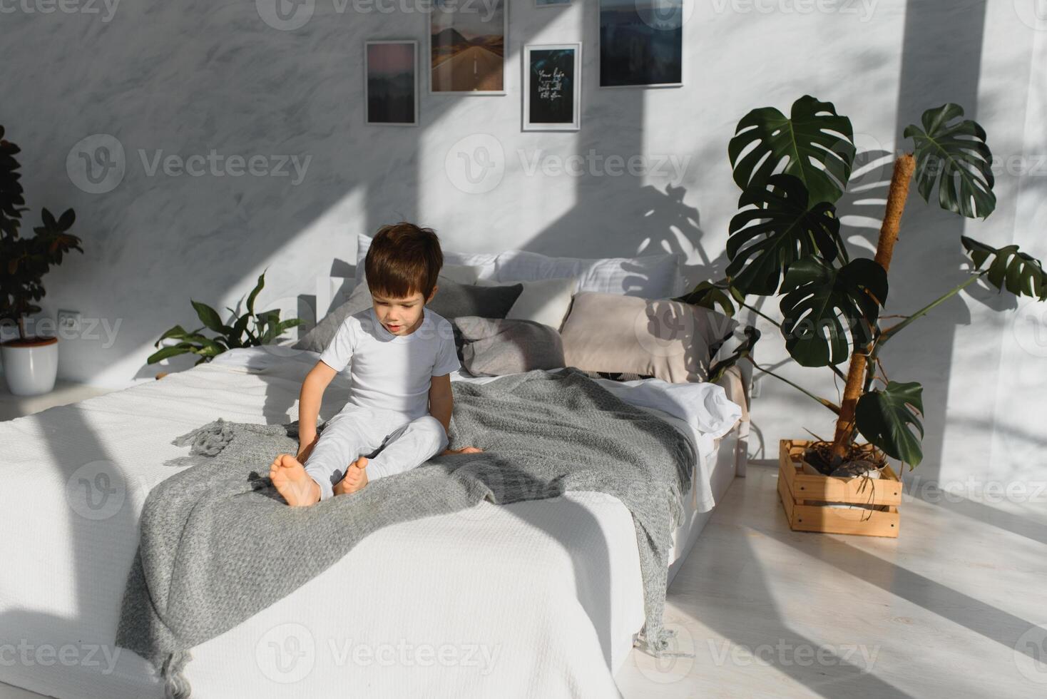 pequeño chico vistiendo blanco pijama en cama foto