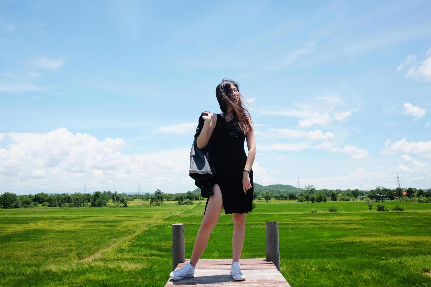 Asian sexy woman standing on Wooden bridge with freedom and happy on the blue sky. Happiness of life is successful and travel in the world. photo