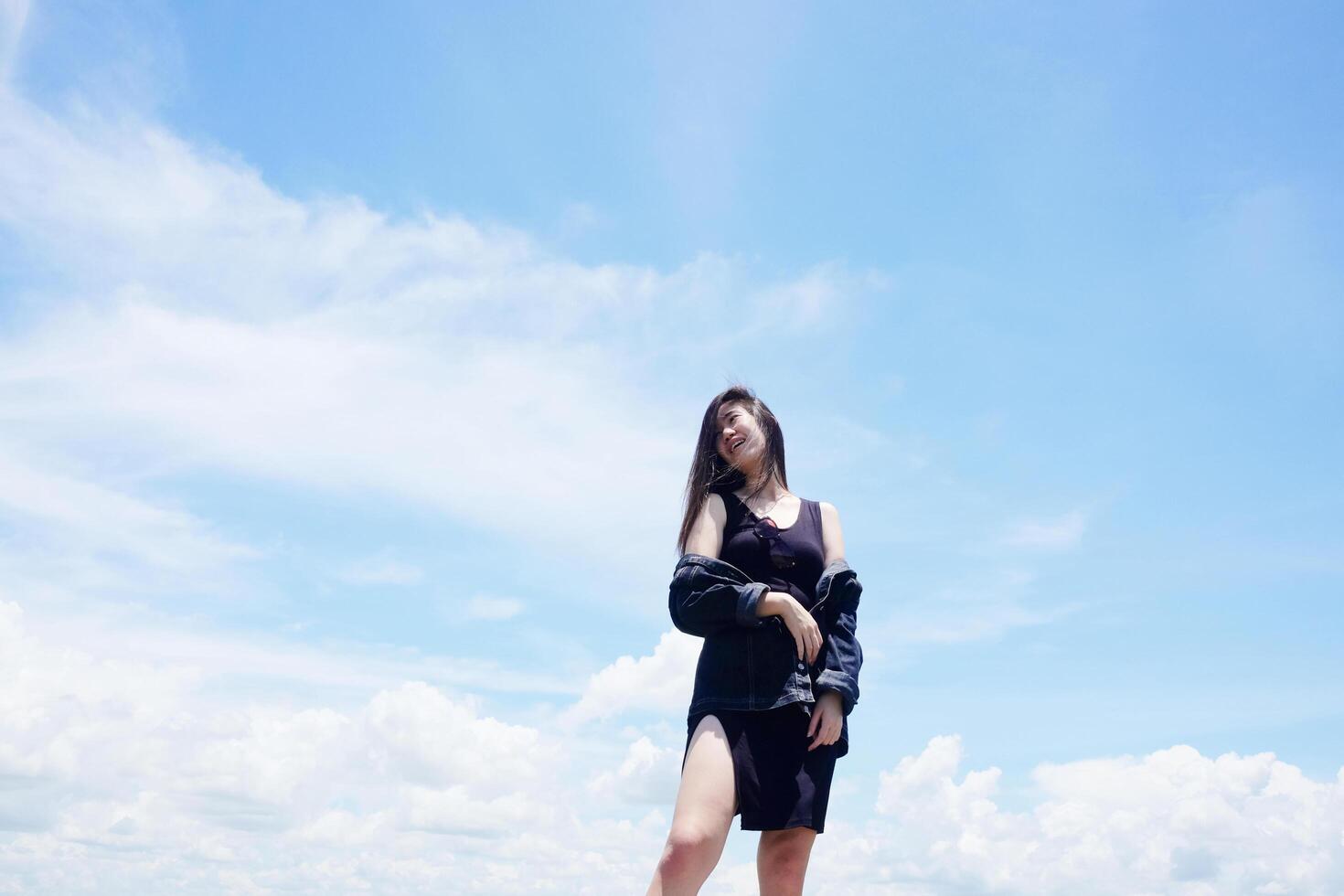 Asian woman long hair standing with blue sky for freedom and happy in the wind. Happiness of life is successful and travel in the world. photo