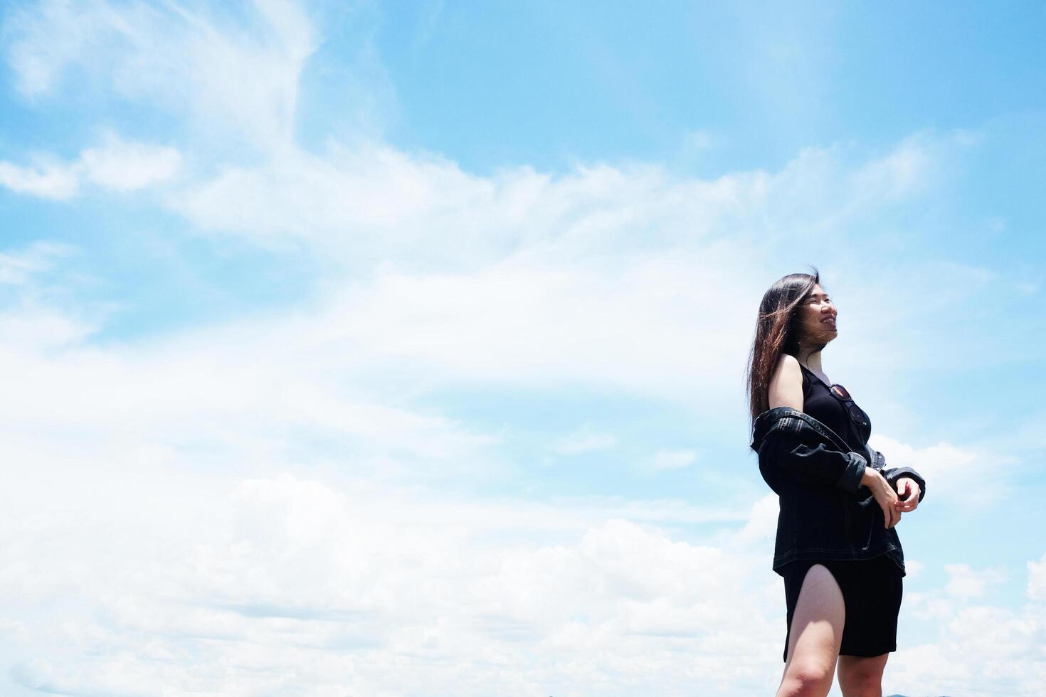 Asian woman long hair standing with blue sky for freedom and happy in the wind. Happiness of life is successful and travel in the world. photo