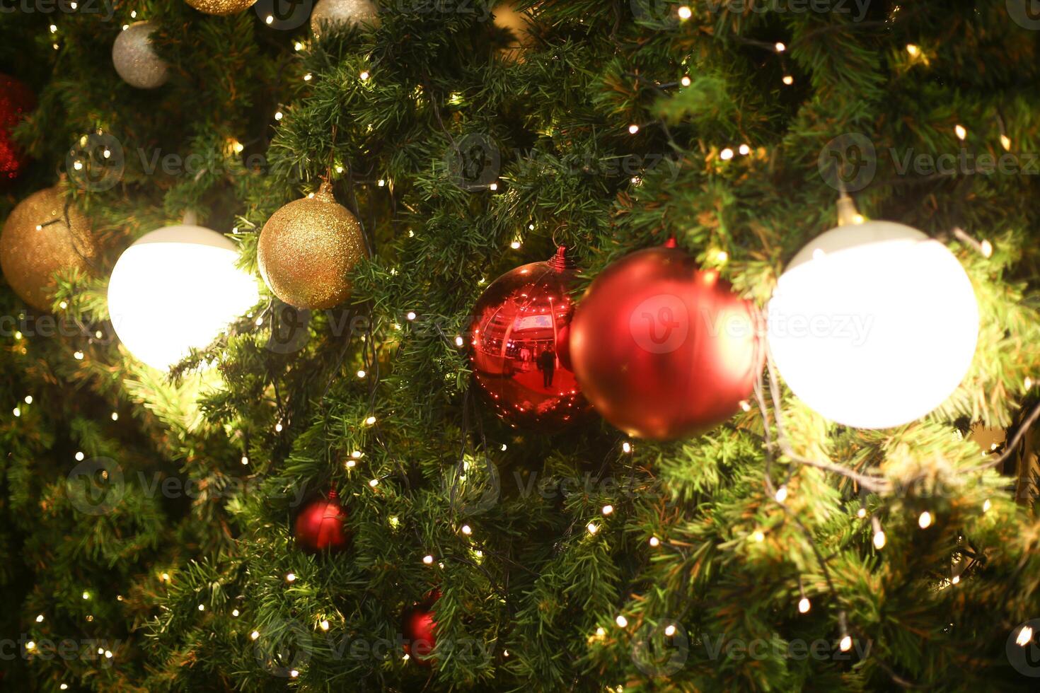 close up decoration ball and light bulb bokeh on Christmas tree at night time on holiday xmas theme photo