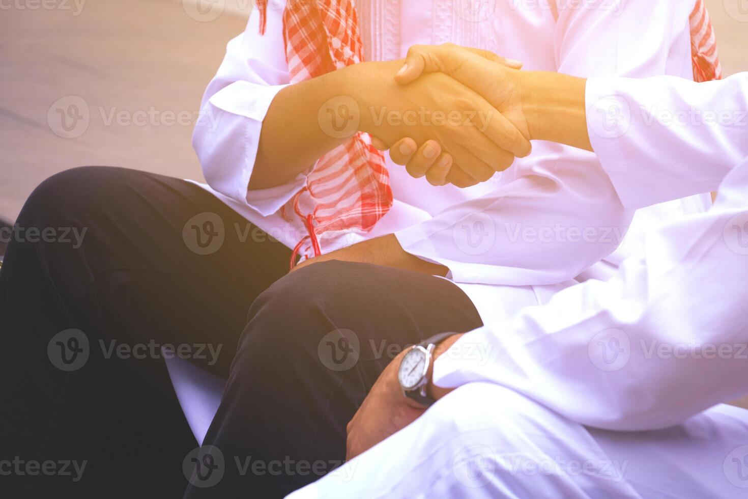 Islamic business man.They are Shaking hands and Gladness in work.They are Successful in business.Arabic Business Concept photo