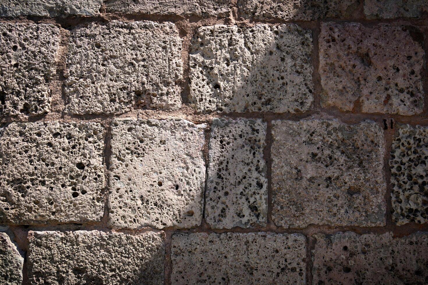 Old brick wall with hewn stone for texture and background in design. photo
