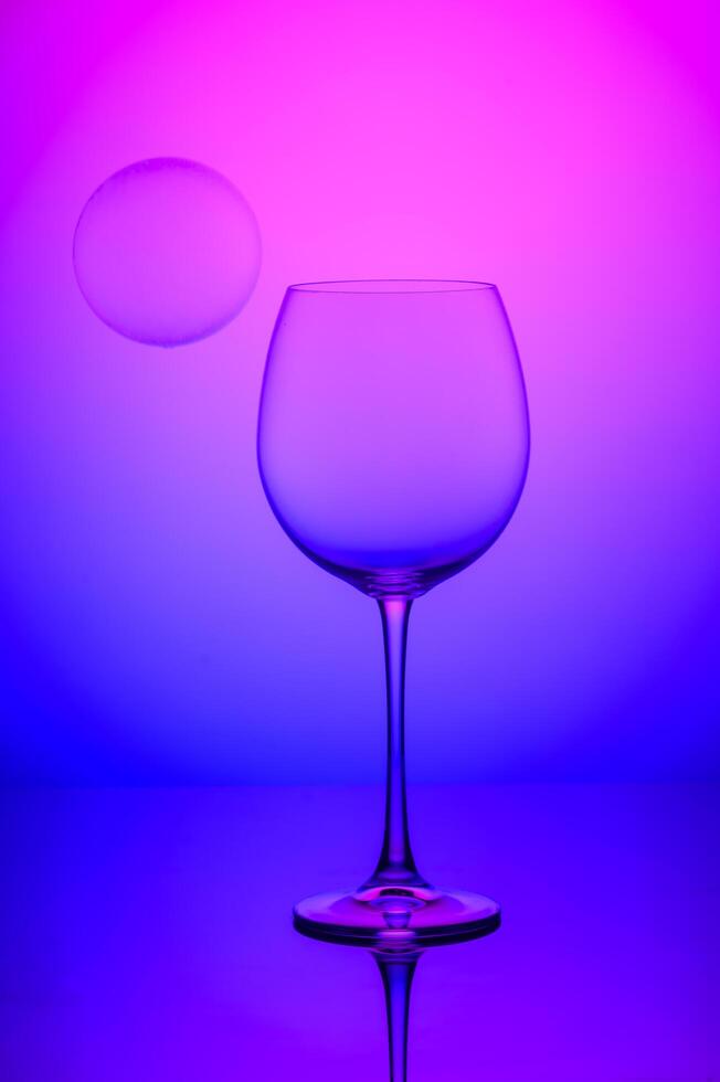 wine glass with soap bubbles on blue and pink background 2 photo