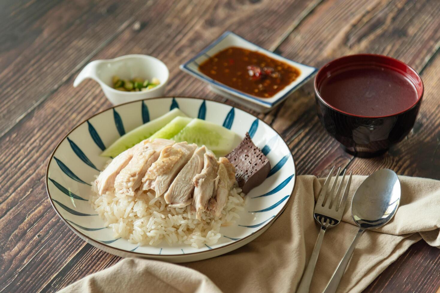 Hainanese Chicken rice with salted soya beans sauce and soup on wooden table photo