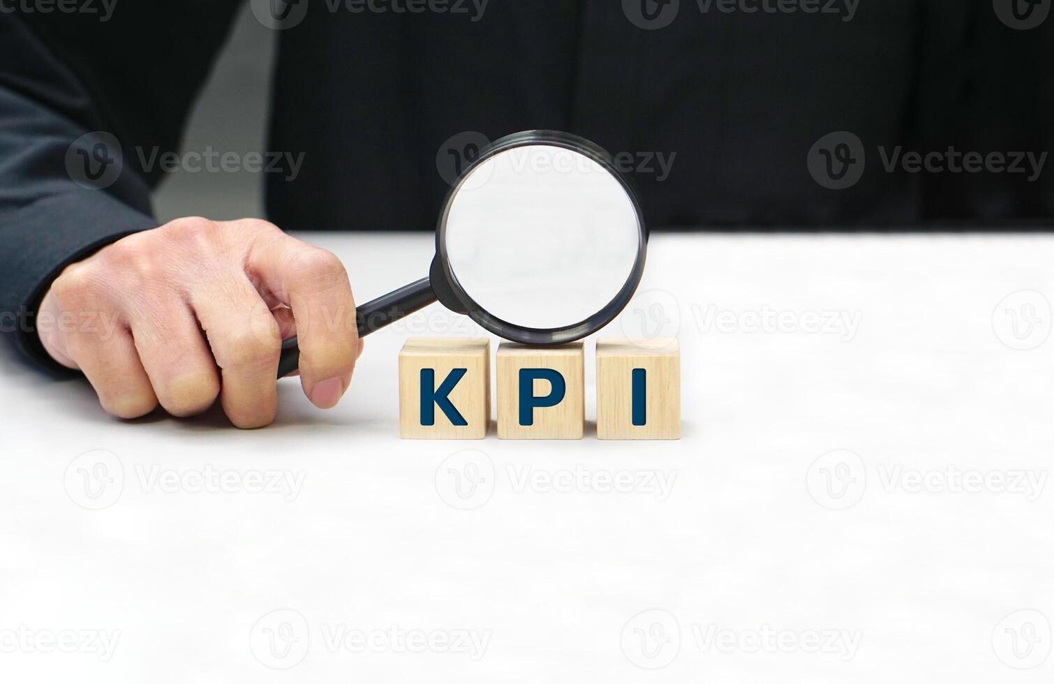 Hand of businessperson looking at wooden blocks with various icon symbols through magnifying glass. Concept of business strategy and action plan. photo
