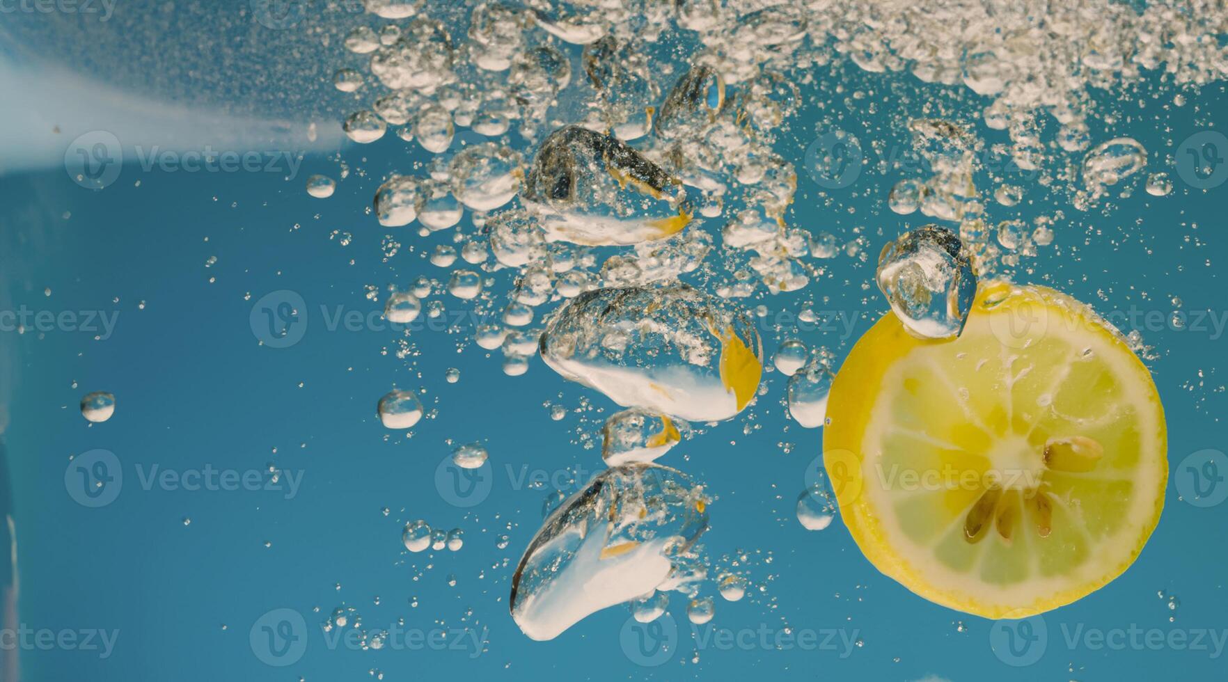 Underwater lemon slice in soda water or lemonade with bubbles. photo