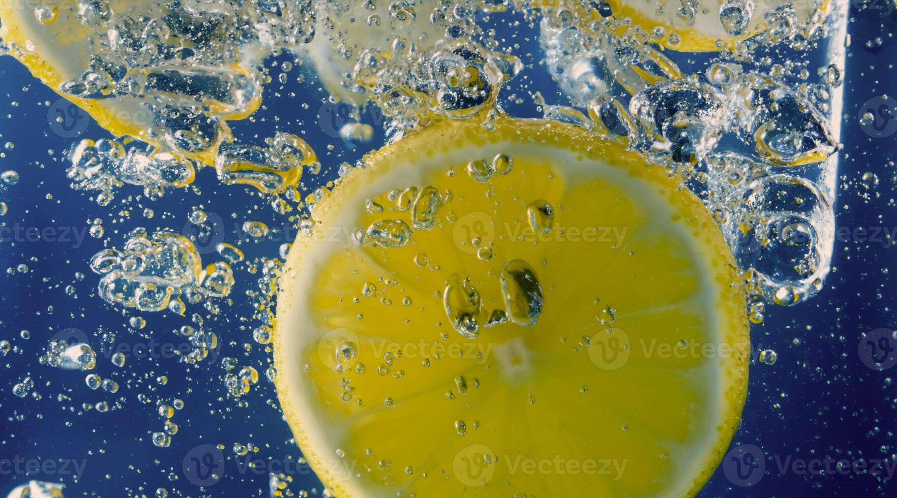 Underwater lemon slice in soda water or lemonade with bubbles. photo