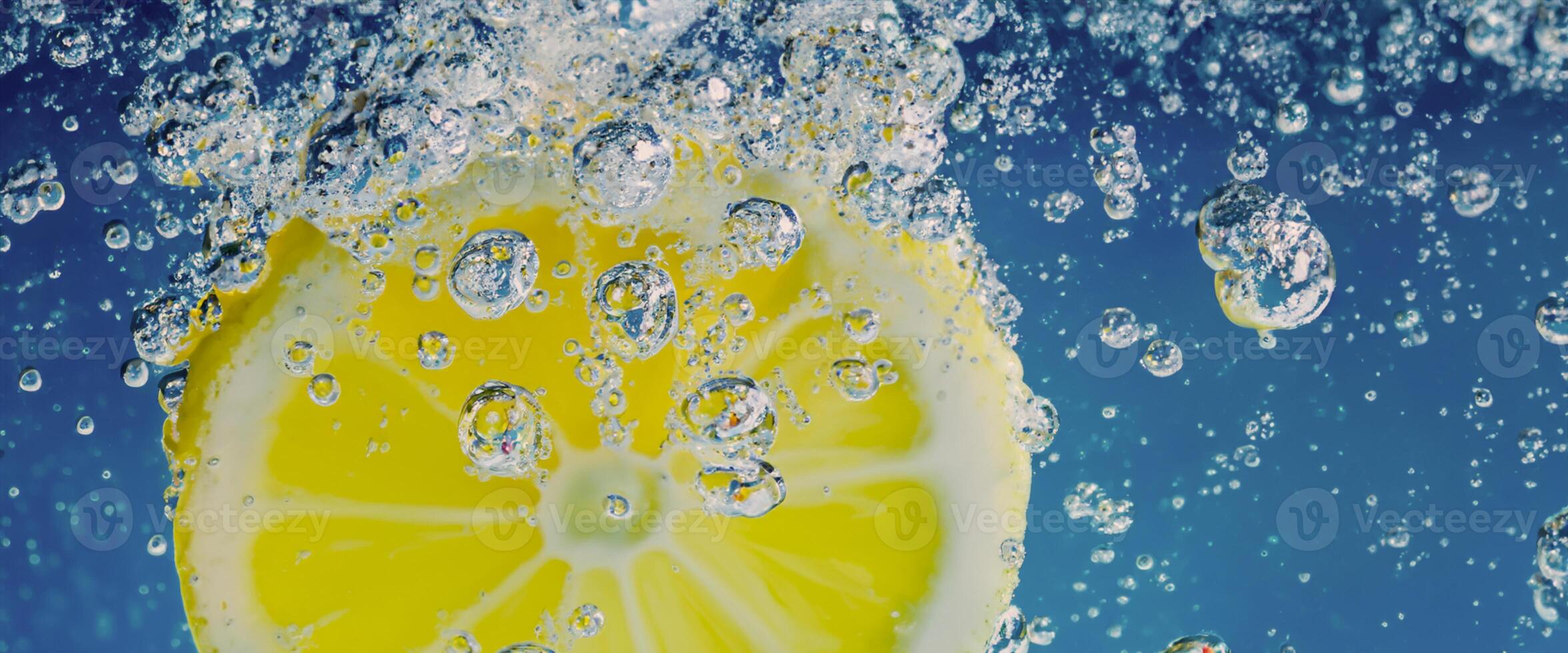 Underwater lemon slice in soda water or lemonade with bubbles. photo