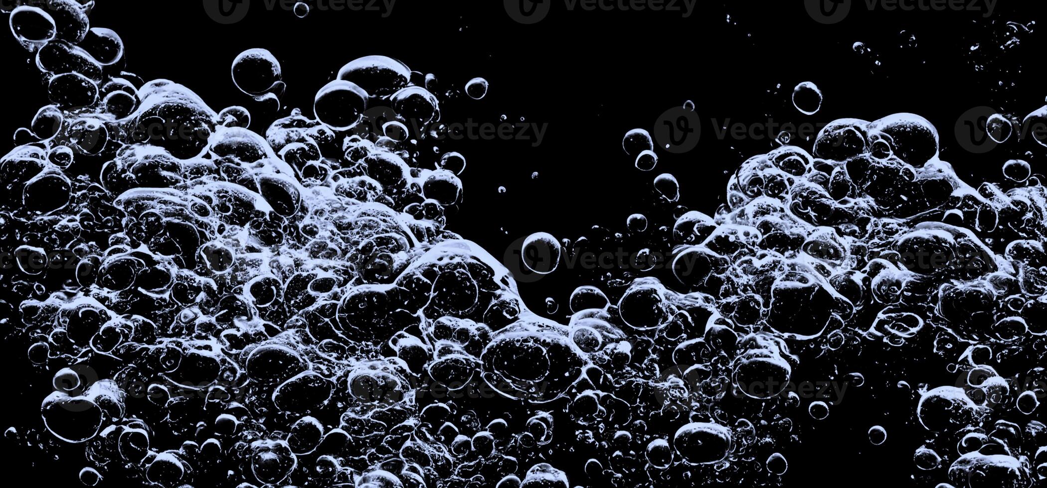 Soda water bubbles splashing underwater against black background. photo