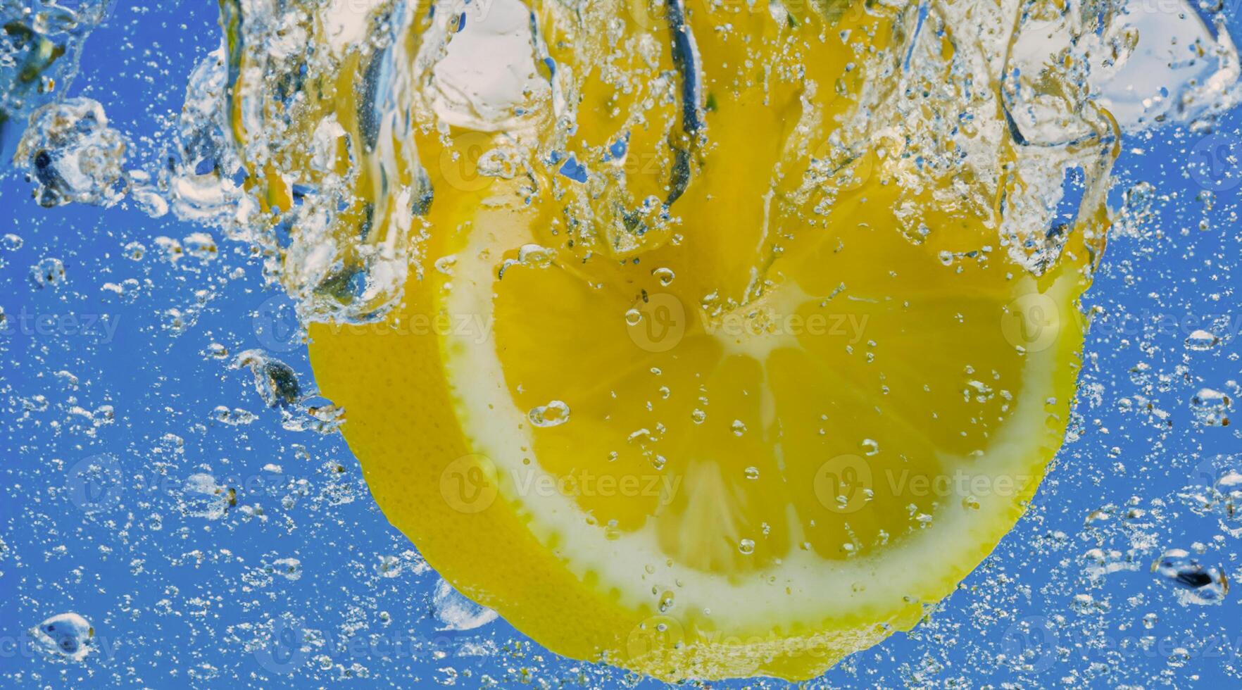 Underwater lemon slice in soda water or lemonade with bubbles. photo