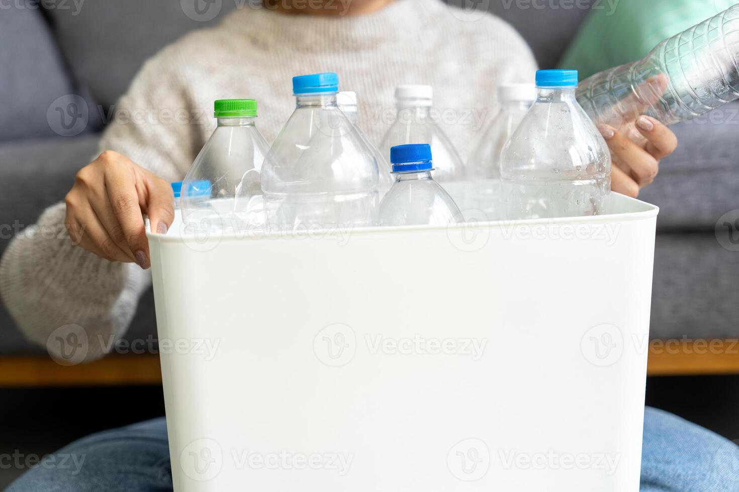 Happy Asian woman keep plastic bottle into trash bins box at home or office. Hand Sorting Recycle garbage. Environmental, trash Separation concept photo