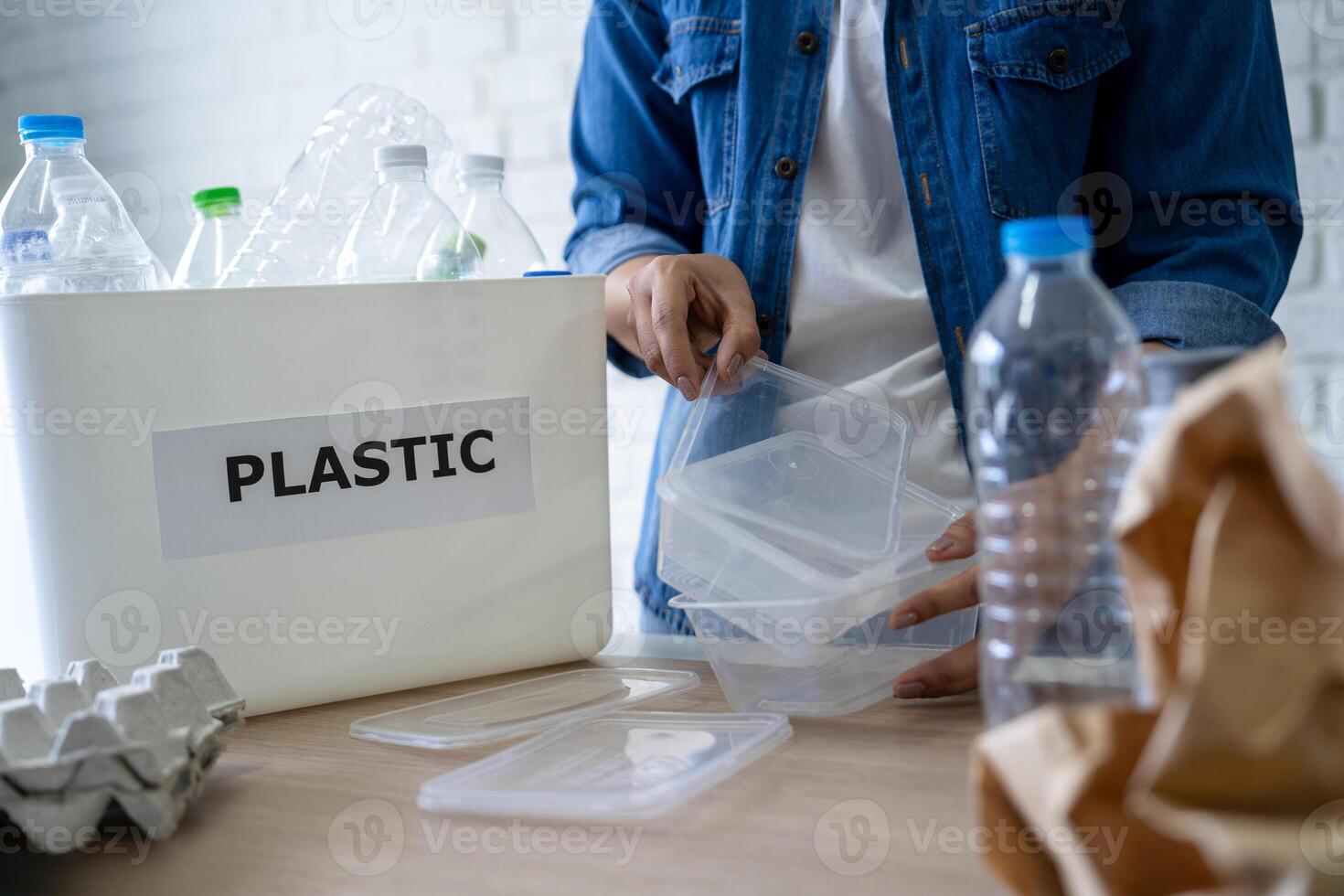 foto de asiático mujer manos poniendo vacío el plastico botellas en el reciclaje compartimiento.