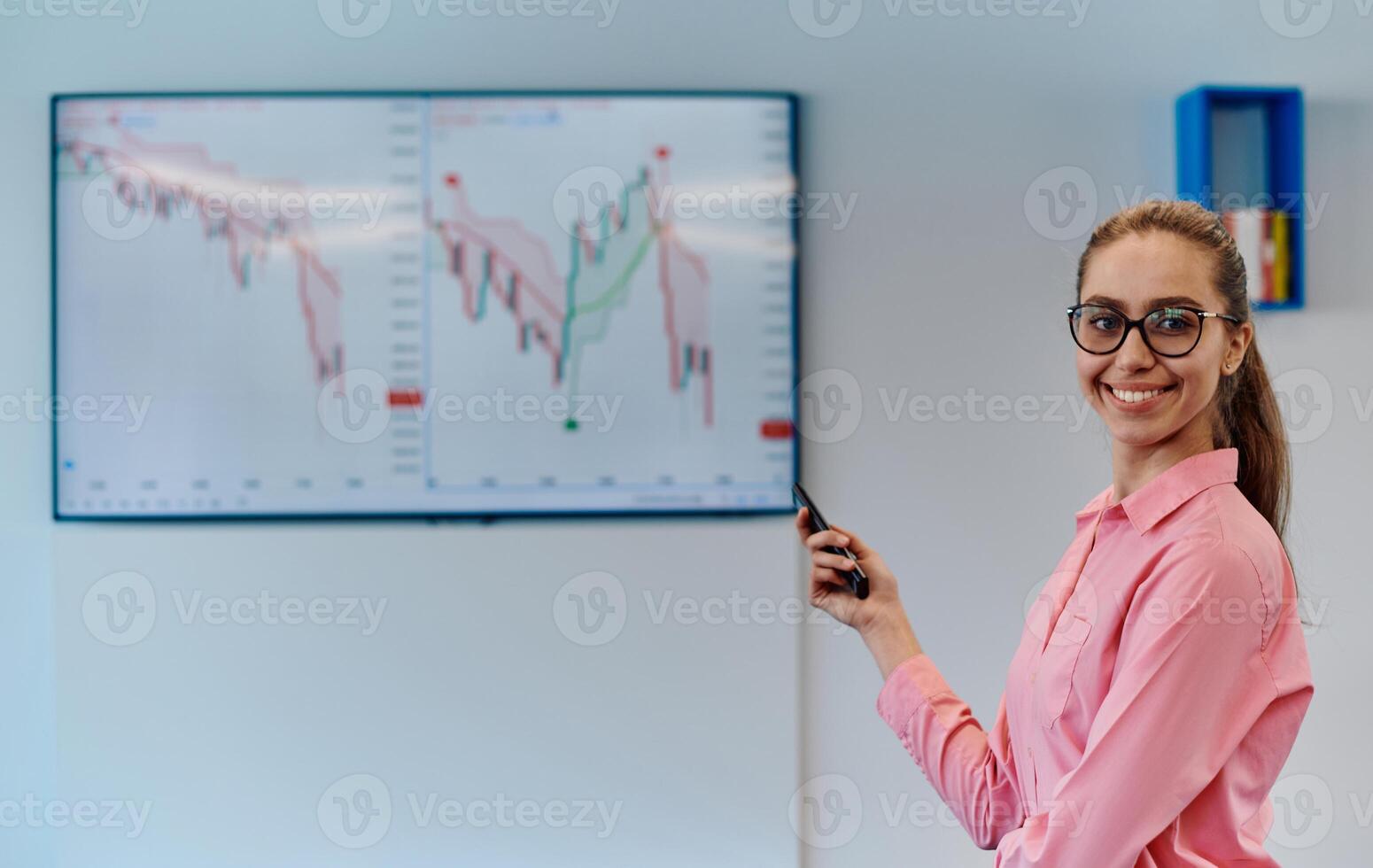 On Stage, Successful Female Speaker Presents Technological Product, Uses Remote Control for Presentation, Showing Infographics, Statistics Animation on Screen. Live Event Device Release photo