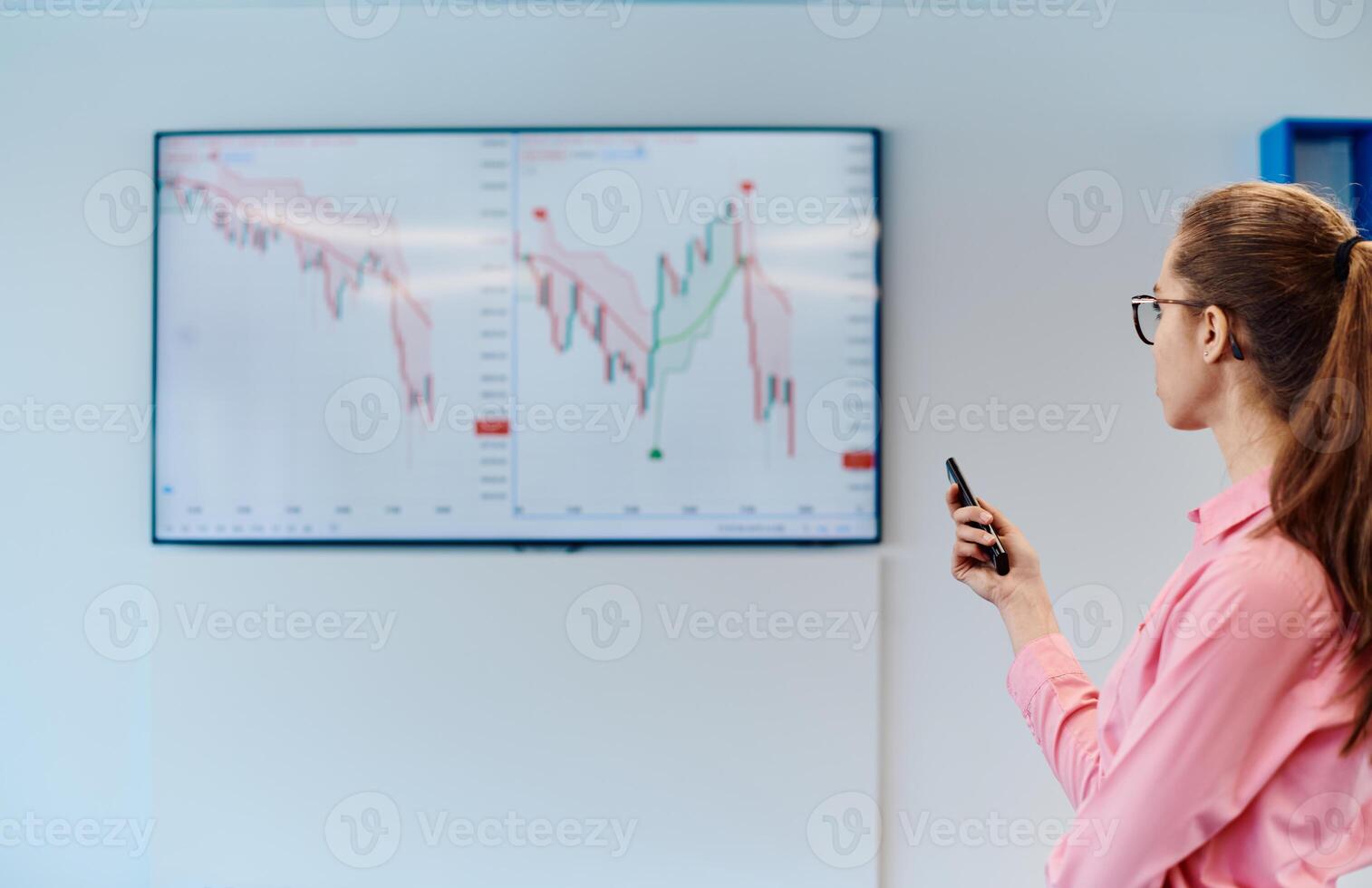 On Stage, Successful Female Speaker Presents Technological Product, Uses Remote Control for Presentation, Showing Infographics, Statistics Animation on Screen. Live Event Device Release photo