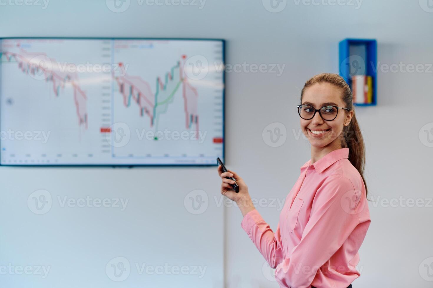 On Stage, Successful Female Speaker Presents Technological Product, Uses Remote Control for Presentation, Showing Infographics, Statistics Animation on Screen. Live Event Device Release photo