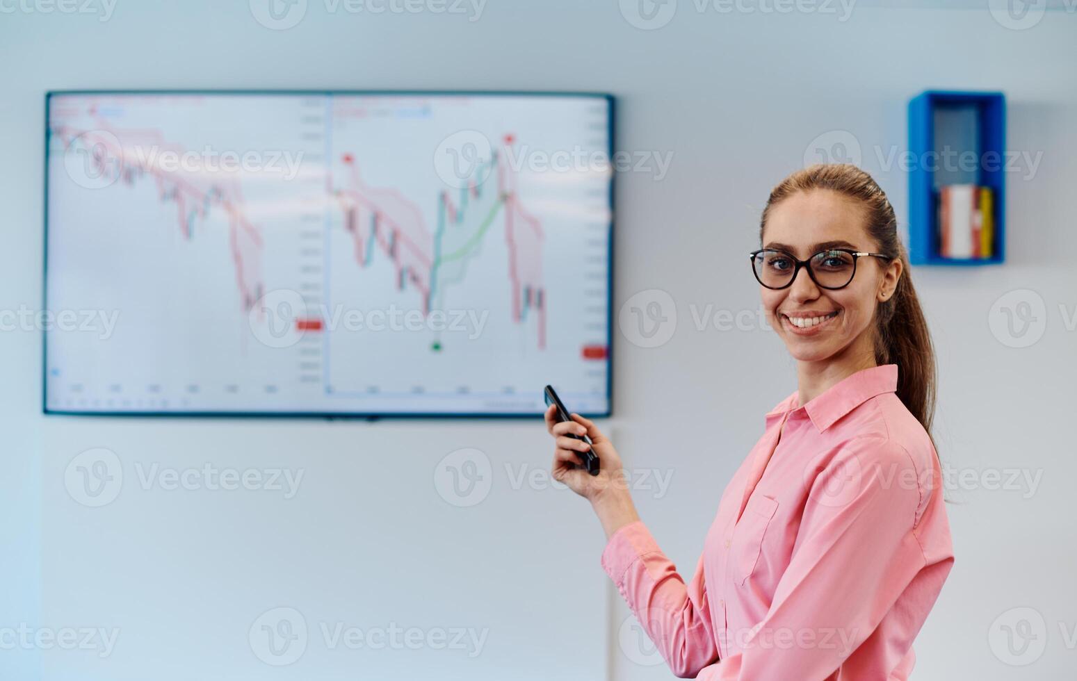On Stage, Successful Female Speaker Presents Technological Product, Uses Remote Control for Presentation, Showing Infographics, Statistics Animation on Screen. Live Event Device Release photo