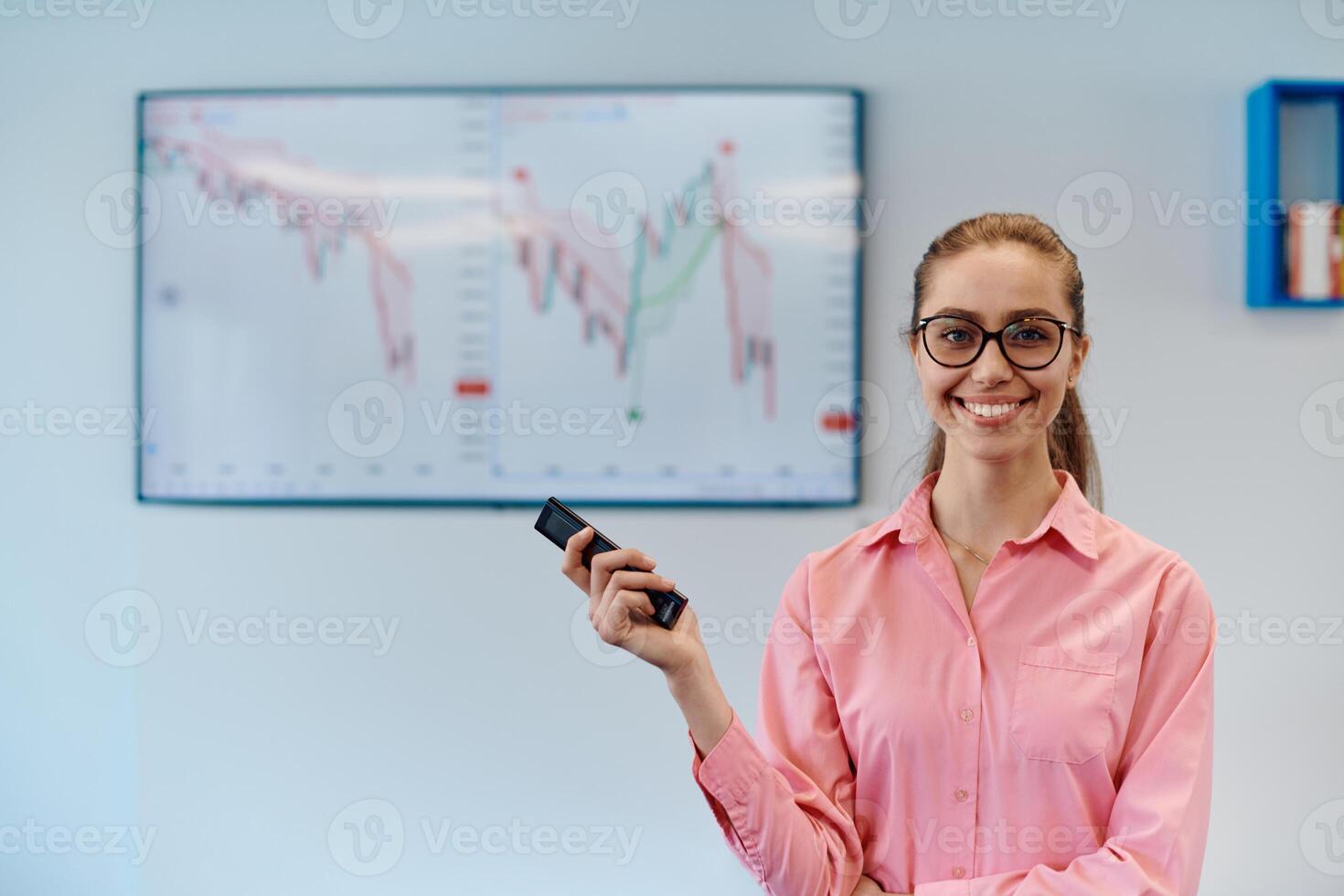 On Stage, Successful Female Speaker Presents Technological Product, Uses Remote Control for Presentation, Showing Infographics, Statistics Animation on Screen. Live Event Device Release photo