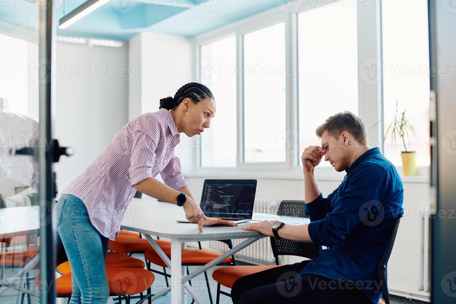 A furious business director of a startup office berating her employee for business mistakes and errors photo