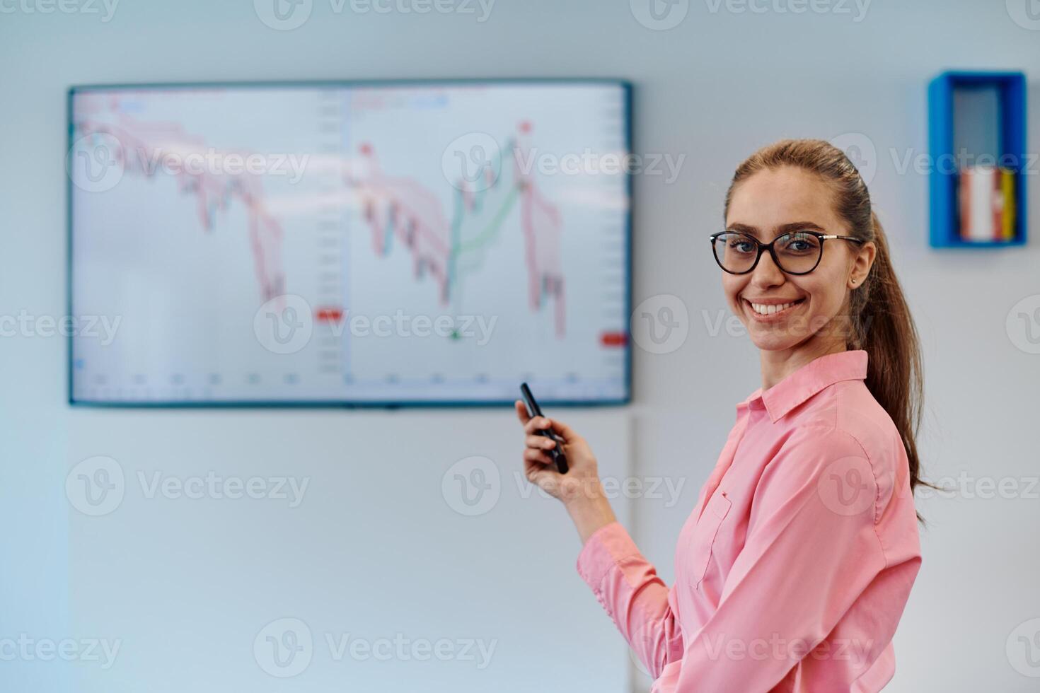 On Stage, Successful Female Speaker Presents Technological Product, Uses Remote Control for Presentation, Showing Infographics, Statistics Animation on Screen. Live Event Device Release photo
