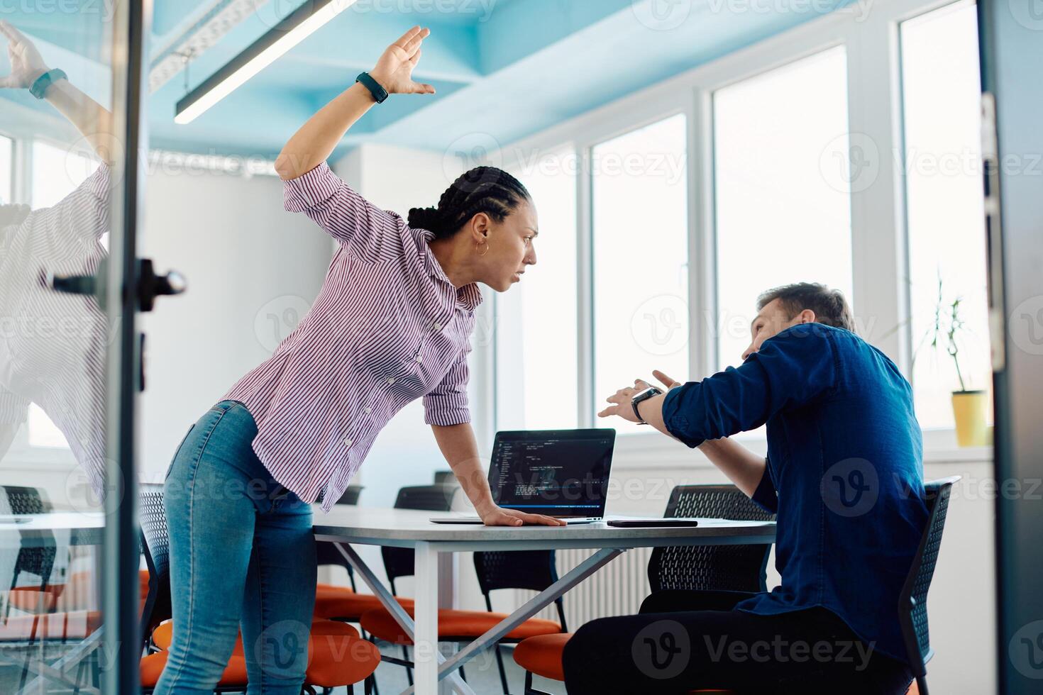 A furious business director of a startup office berating her employee for business mistakes and errors photo