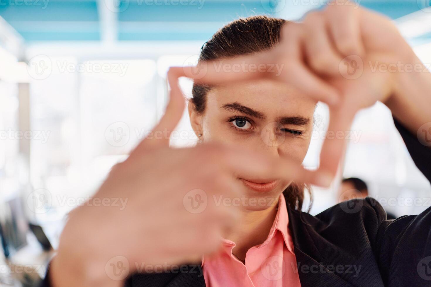 Closeup of hands, Smiling Business Woman Making Frame Gesture with at modern bright coworking open space startup office photo