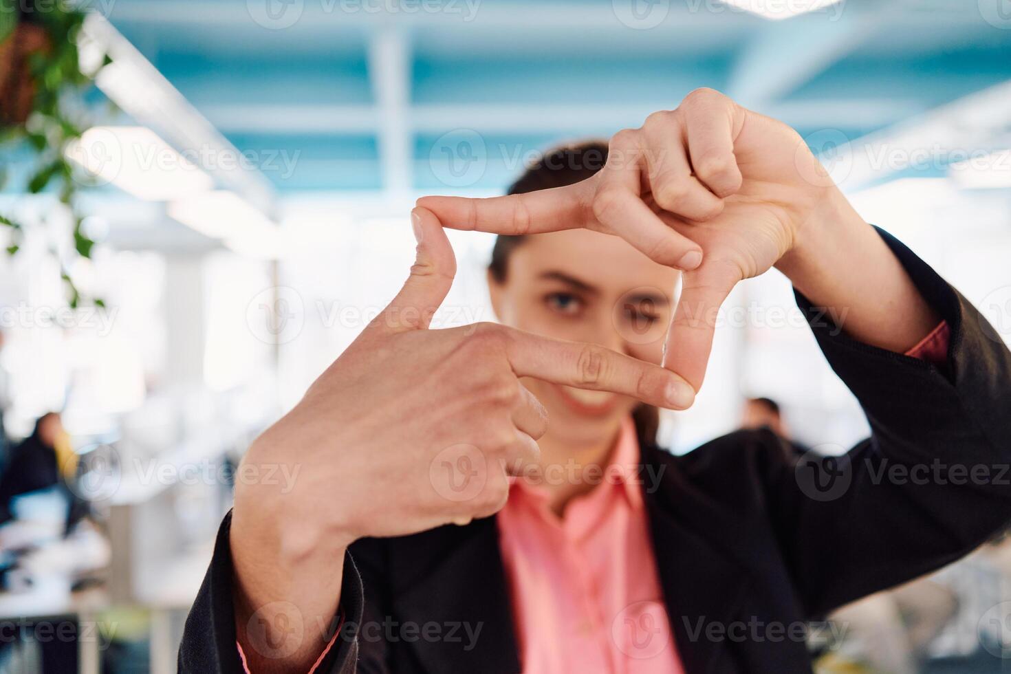 Closeup of hands, Smiling Business Woman Making Frame Gesture with at modern bright coworking open space startup office photo