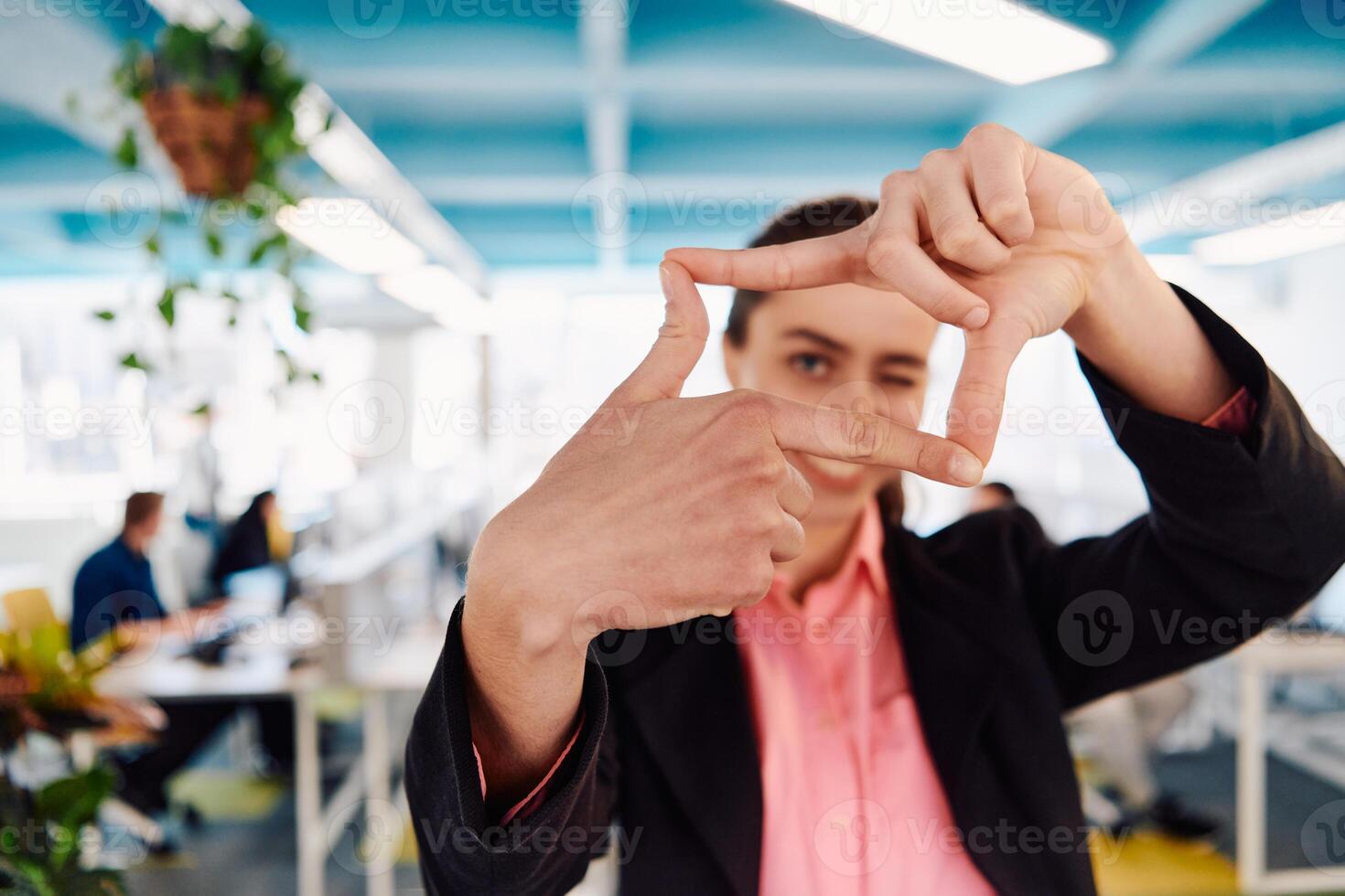 Closeup of hands, Smiling Business Woman Making Frame Gesture with at modern bright coworking open space startup office photo