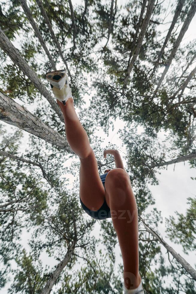 Adventurous Woman Overcoming Forest Obstacles with Determination and Agility. photo