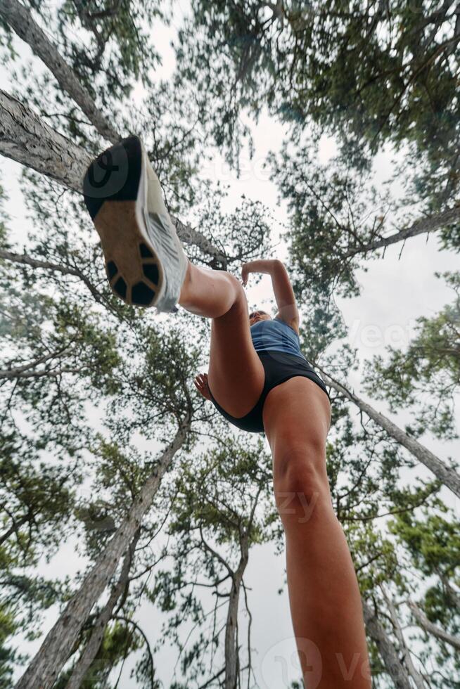 Adventurous Woman Overcoming Forest Obstacles with Determination and Agility. photo