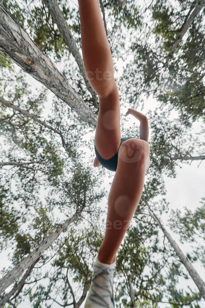 Adventurous Woman Overcoming Forest Obstacles with Determination and Agility. photo
