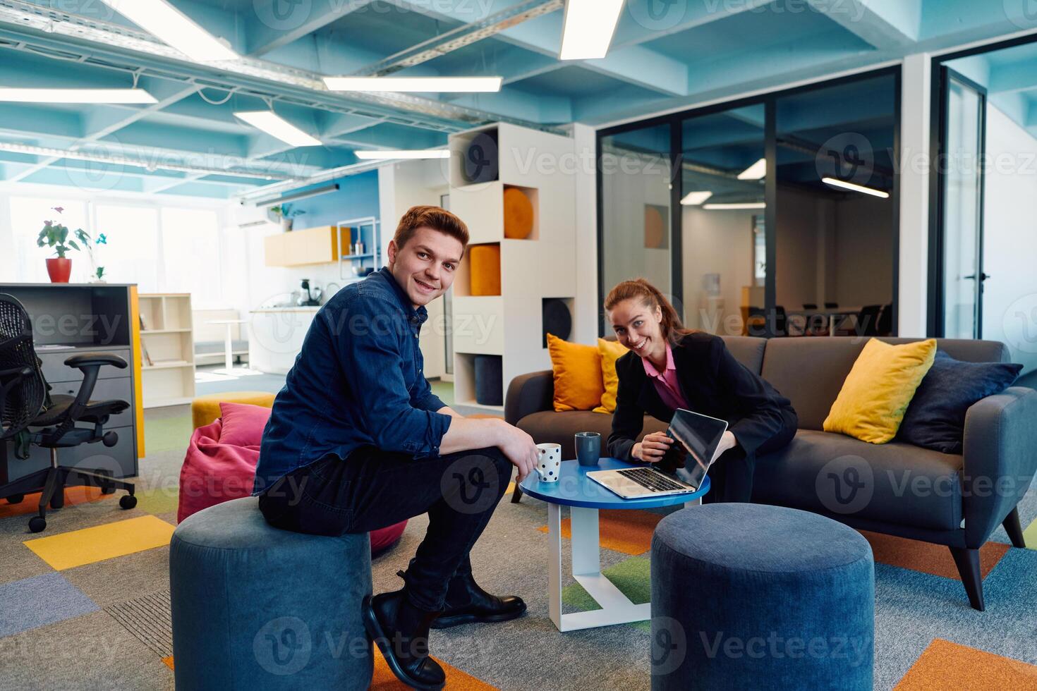 Multiethnic startup business team on meeting in a modern bright open space coworking office. Brainstorming, working on laptop. Group of coworkers walking around in motion blur photo