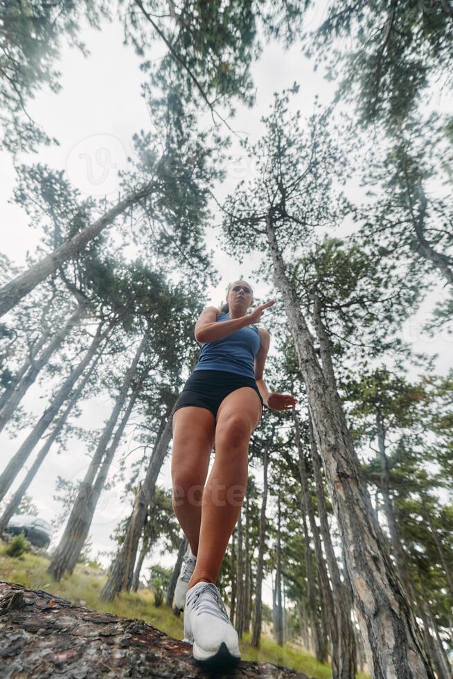 Adventurous Woman Overcoming Forest Obstacles with Determination and Agility. photo