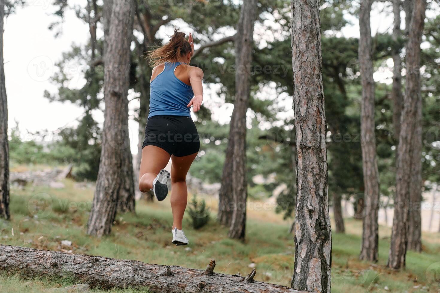 Fearless Woman Conquering Wooden Obstacles in the Dangerous Forest Terrain. photo